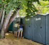 Des cabines WC autonome Festi de WC Loc, installée sous les arbres lors d’un événement