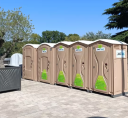 Toilettes sèches mobiles installées sur une place publique en ville, avec des cabines WC Loc prêtes à accueillir les utilisateurs lors d’un événement.