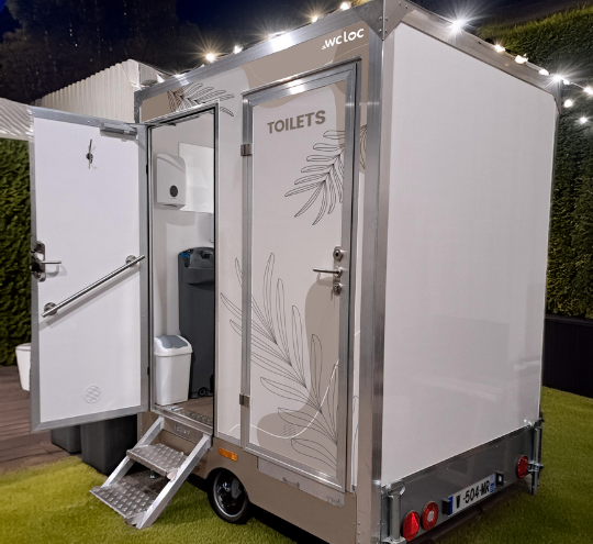 Caravane sanitaire FESTI de WC Loc, élégante et moderne, installée dans un espace extérieur.