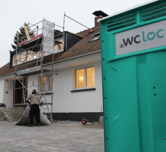 Toilette mobile WC Loc installée devant une maison en rénovation