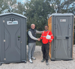 Jérôme Tappela, directeur de WC Loc PACA, serre la main du fondateur de WC+ Sud devant des cabines de toilettes mobiles WC Loc à Marseille.
