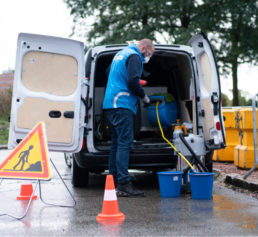 Agent Bases Clean réalisant le nettoyage et la maintenance de WC Loc avec équipement professionnel sur chantier.